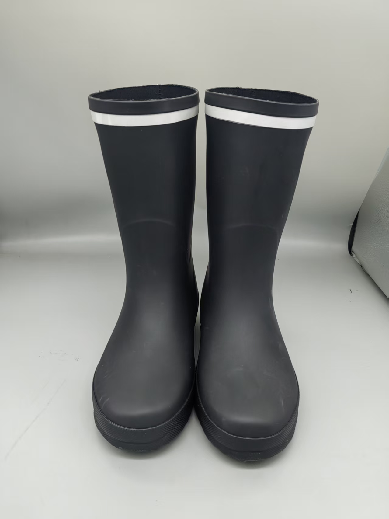 Black kids latex rain boots with white trim at top