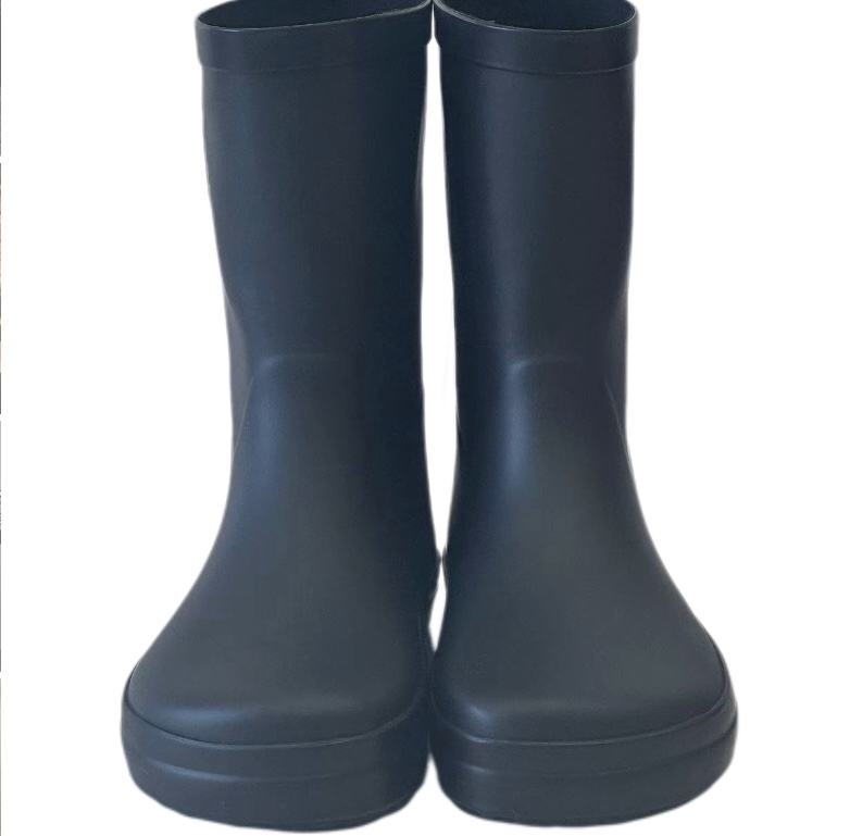 Kids wearing black latex rain boots in a garden